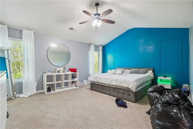 bedroom with lofted ceiling, multiple windows, carpet, and visible vents