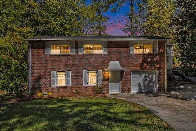 view of front of home with a garage and a lawn