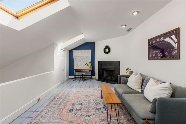 living area featuring a skylight, tile patterned floors, a high end fireplace, lofted ceiling, and baseboards