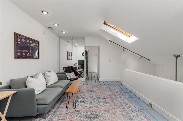 tiled living area featuring a skylight, recessed lighting, and baseboards