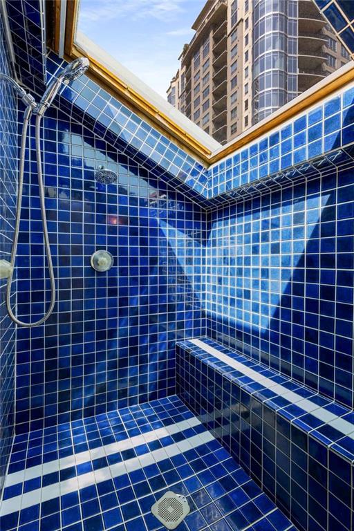 bathroom featuring tile patterned flooring and a tile shower