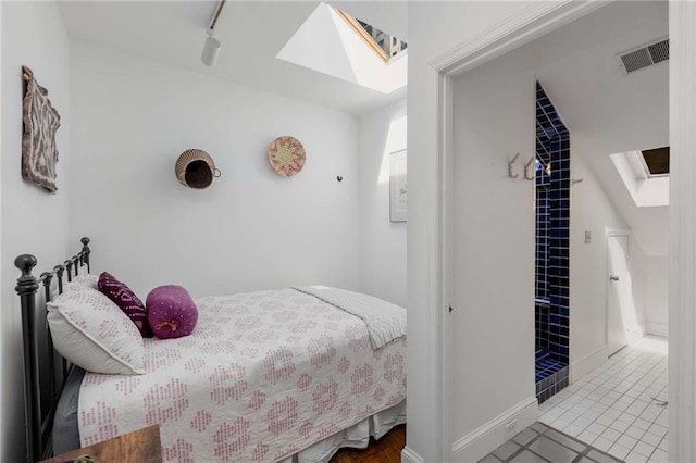 tiled bedroom with a skylight and baseboards