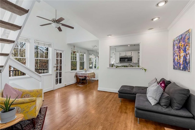 living room with stairs, ceiling fan, wood finished floors, ornamental molding, and recessed lighting