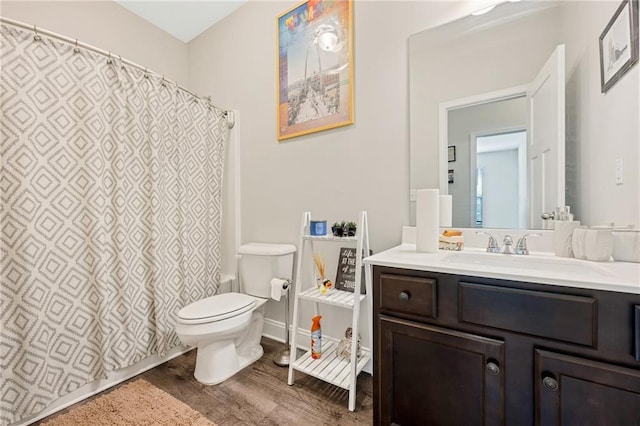 bathroom featuring wood-type flooring, vanity, and toilet