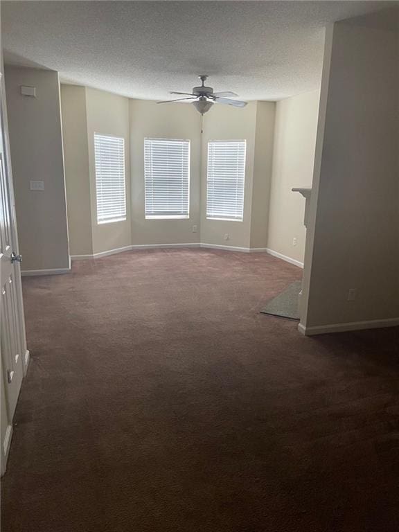 carpeted empty room featuring ceiling fan and a textured ceiling