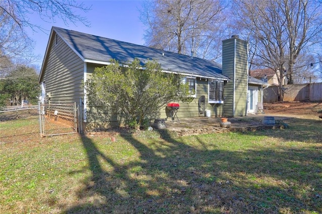 back of property with a lawn and a patio