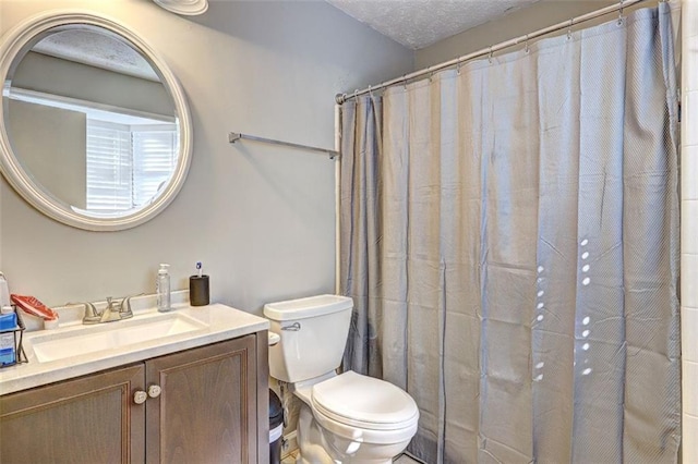 bathroom featuring vanity, a textured ceiling, and toilet