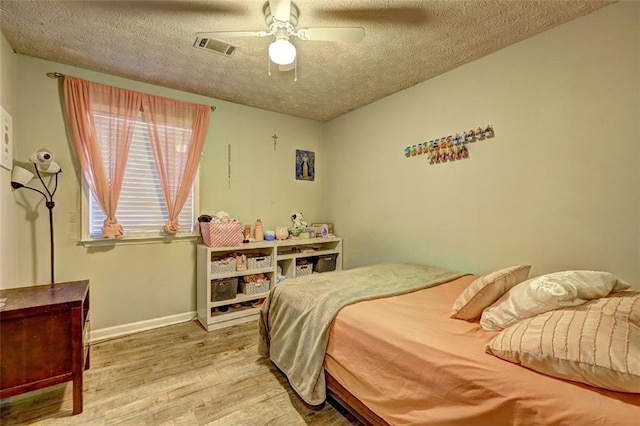 bedroom featuring hardwood / wood-style flooring, ceiling fan, and a textured ceiling