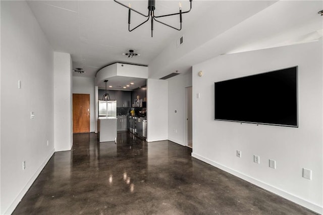 unfurnished living room with finished concrete flooring, baseboards, and a chandelier