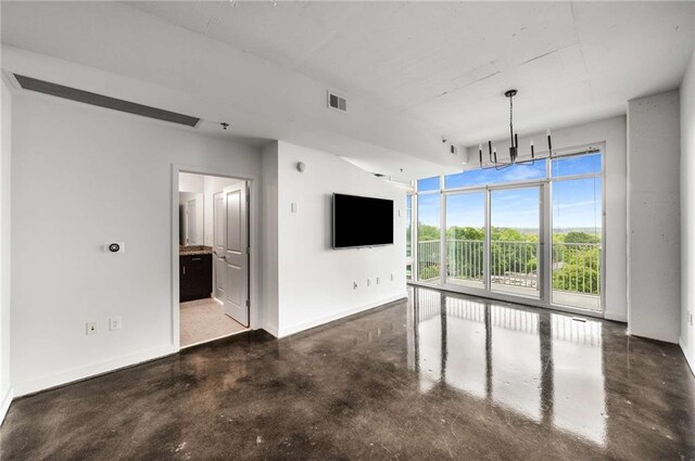unfurnished living room featuring concrete flooring and baseboards
