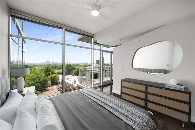 bedroom with access to exterior, a wall of windows, multiple windows, and a view of city