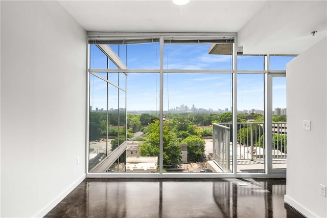 entryway with floor to ceiling windows, baseboards, and a skyline view