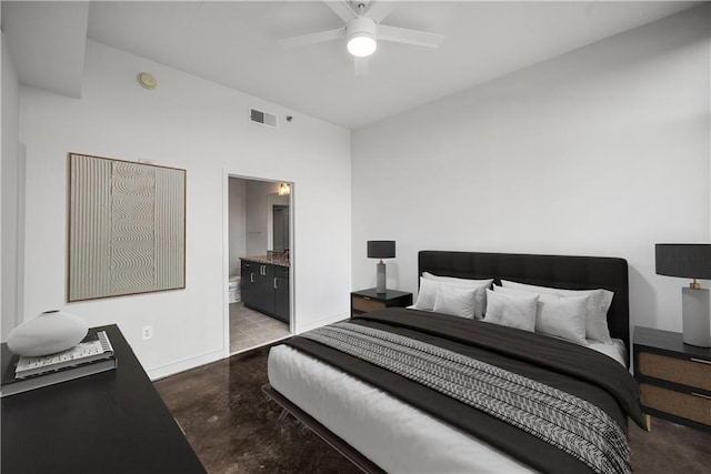 bedroom featuring finished concrete flooring, baseboards, ensuite bathroom, and a ceiling fan