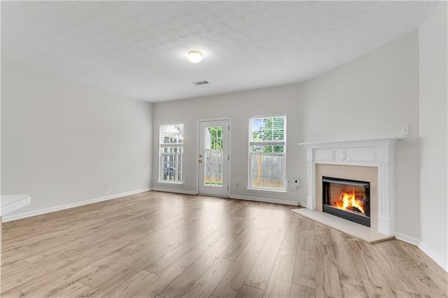 621 Kenridge Way Unit 0, Suwanee, GA 30024 - unfurnished living room with a premium fireplace, wood finished floors, baseboards, and a textured ceiling