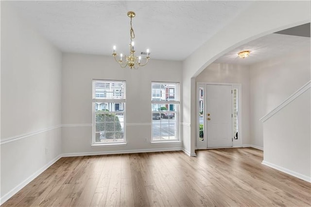 621 Kenridge Way Unit 0, Suwanee, GA 30024 - foyer entrance with arched walkways, wood finished floors, a chandelier, baseboards, and a textured ceiling