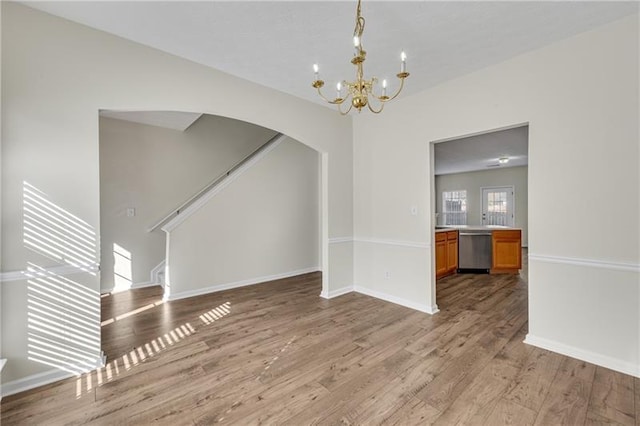 621 Kenridge Way Unit 0, Suwanee, GA 30024 - unfurnished dining area with arched walkways, a chandelier, light wood-type flooring, and baseboards