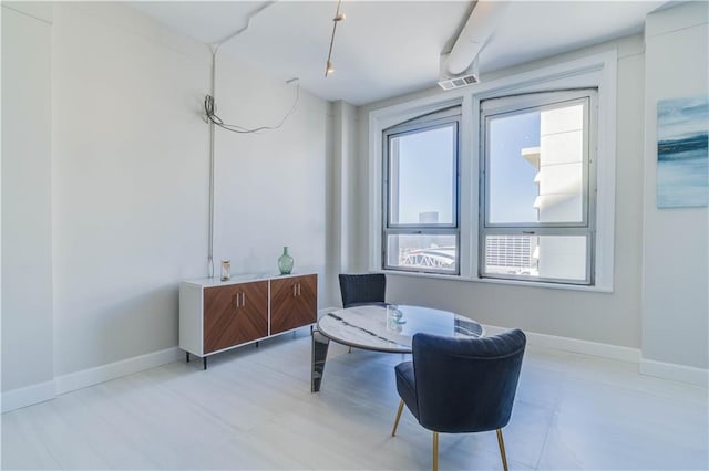 living area featuring baseboards, visible vents, and wood finished floors