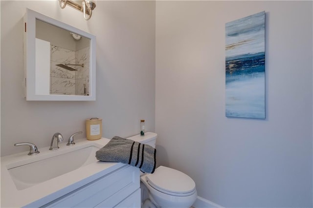 bathroom featuring a shower, toilet, and vanity