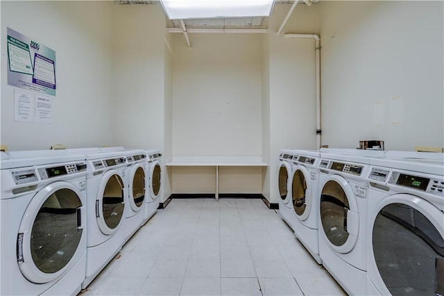 community laundry room featuring washing machine and clothes dryer and baseboards