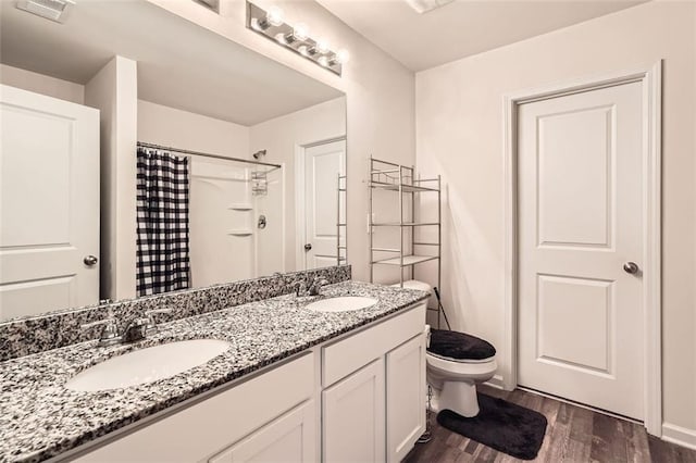 full bathroom featuring curtained shower, visible vents, a sink, and wood finished floors