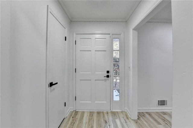 foyer entrance featuring ornamental molding and light hardwood / wood-style flooring