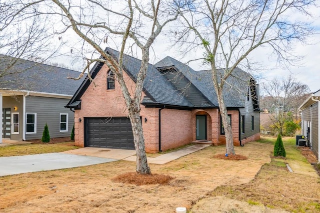 view of front of home featuring a garage, a front yard, and central AC unit