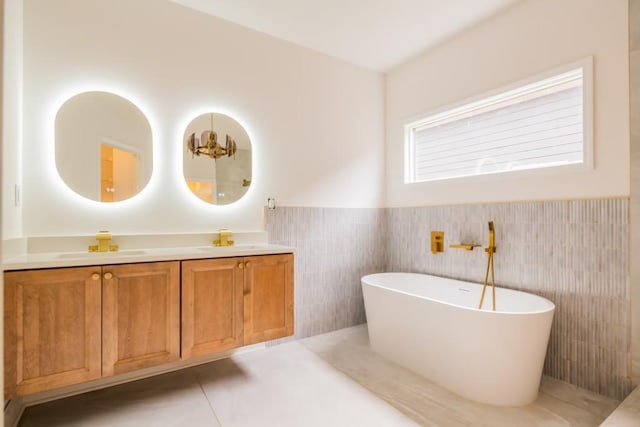 bathroom featuring vanity, a tub, and tile walls