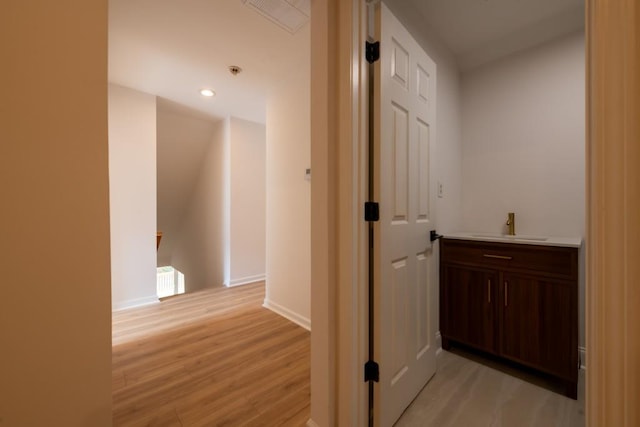 hallway featuring sink and light hardwood / wood-style flooring