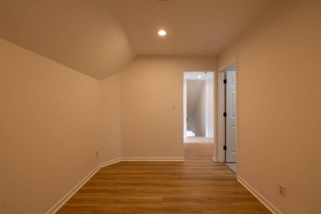 hallway featuring lofted ceiling and light wood-type flooring