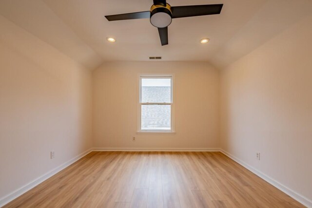 spare room featuring vaulted ceiling, ceiling fan, and light wood-type flooring