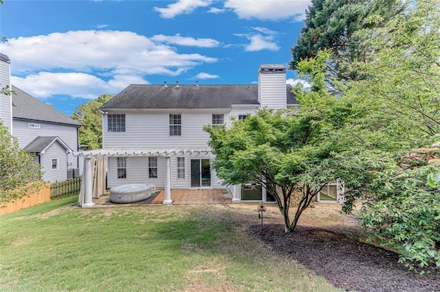 rear view of house with a hot tub, a pergola, a chimney, and a patio area