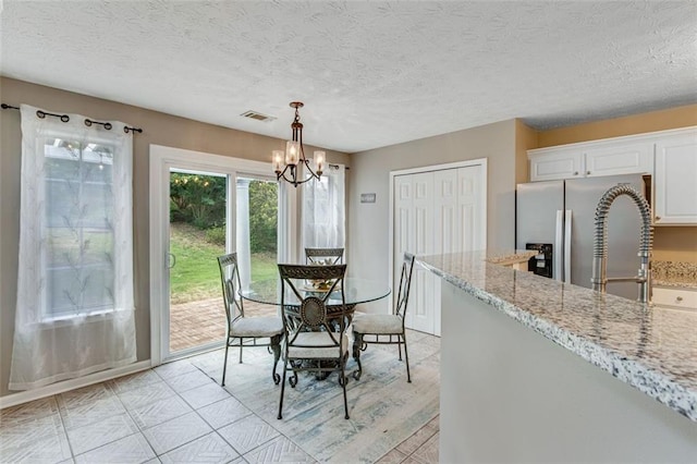 dining room featuring a chandelier and a textured ceiling