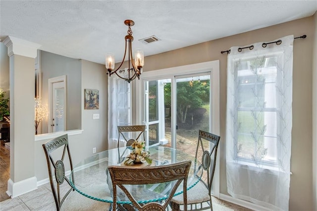 dining area featuring a chandelier, baseboards, and a textured ceiling