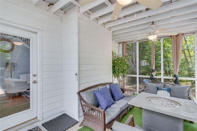 sunroom featuring ceiling fan, an outdoor living space with a fire pit, and beam ceiling
