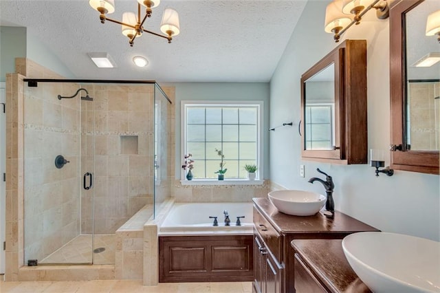 bathroom featuring a bath, a stall shower, a textured ceiling, a chandelier, and double vanity