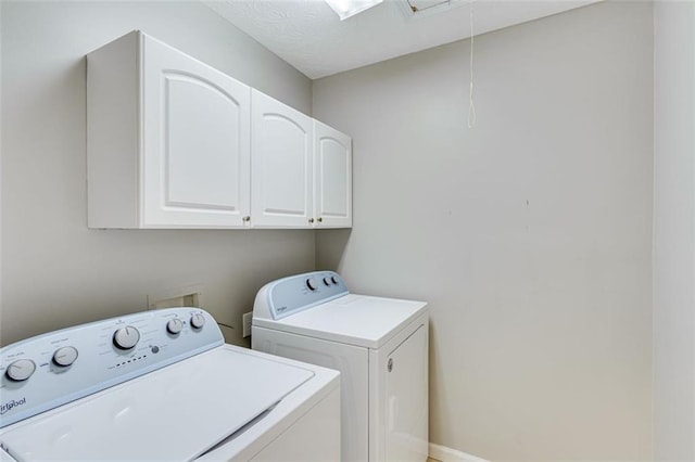 laundry room with cabinet space, attic access, and washing machine and dryer