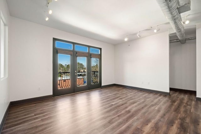 unfurnished room featuring dark wood-style floors, french doors, and baseboards