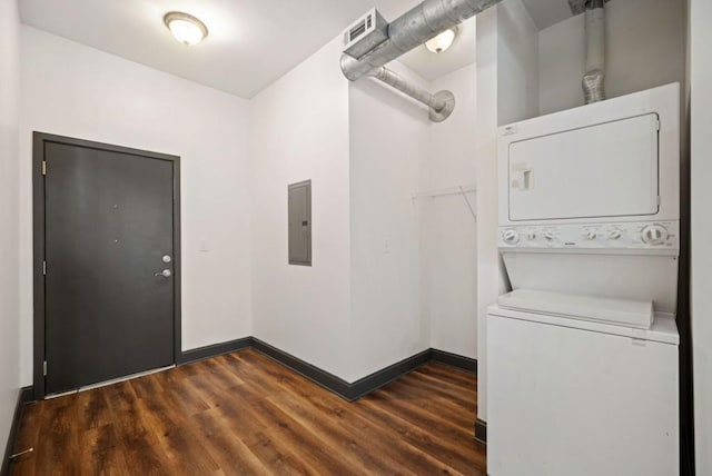 washroom with visible vents, baseboards, stacked washing maching and dryer, electric panel, and dark wood finished floors