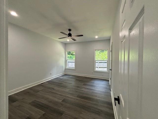 empty room with dark wood-type flooring and ceiling fan