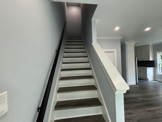 stairs featuring hardwood / wood-style floors and crown molding