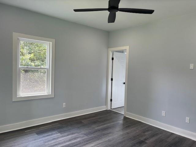 spare room with dark wood-type flooring and ceiling fan