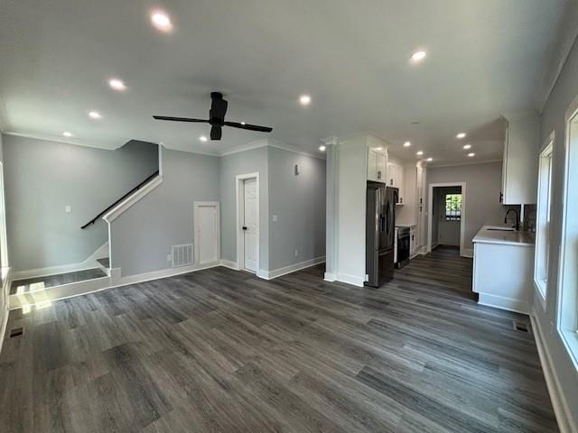 unfurnished living room with crown molding, ceiling fan, dark hardwood / wood-style floors, and sink