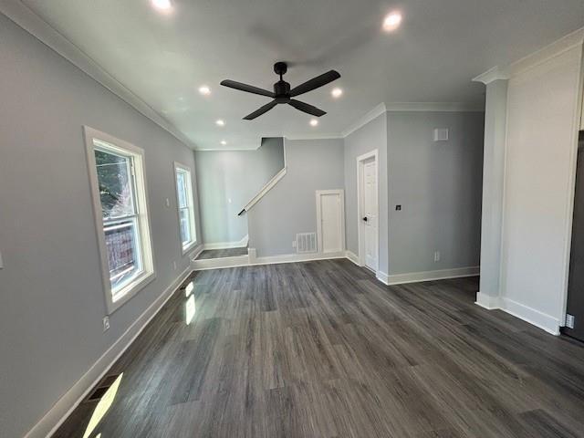 unfurnished living room featuring ornamental molding, dark wood-type flooring, and ceiling fan