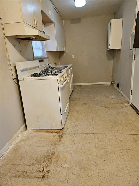 kitchen with white gas range, sink, and white cabinets