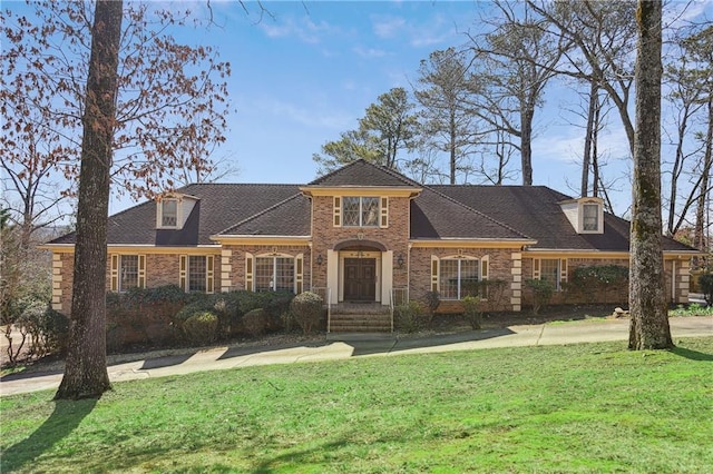 view of front of house featuring brick siding and a front lawn