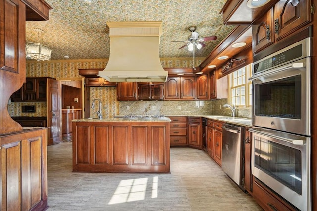 kitchen with premium range hood, wallpapered walls, a sink, stainless steel appliances, and crown molding