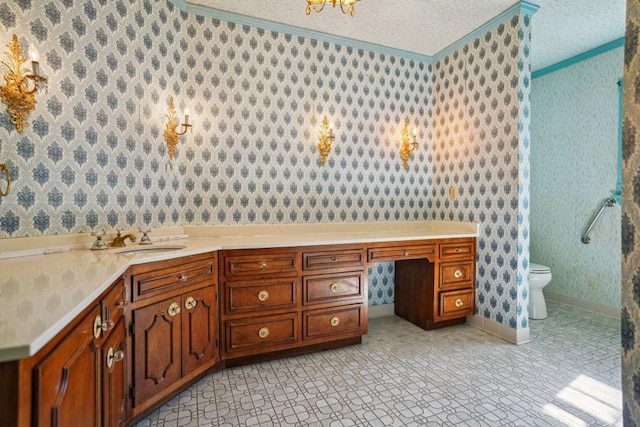 bathroom with wallpapered walls, toilet, ornamental molding, a textured ceiling, and a sink