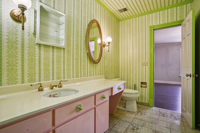 bathroom with visible vents, toilet, vanity, and wallpapered walls