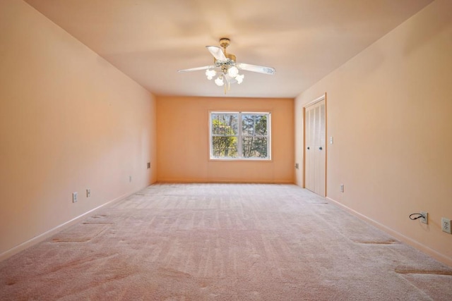 carpeted empty room featuring baseboards and ceiling fan