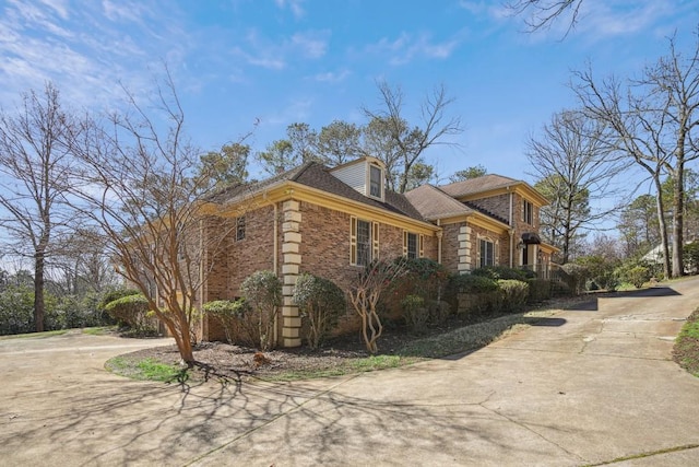 view of side of property with concrete driveway and brick siding